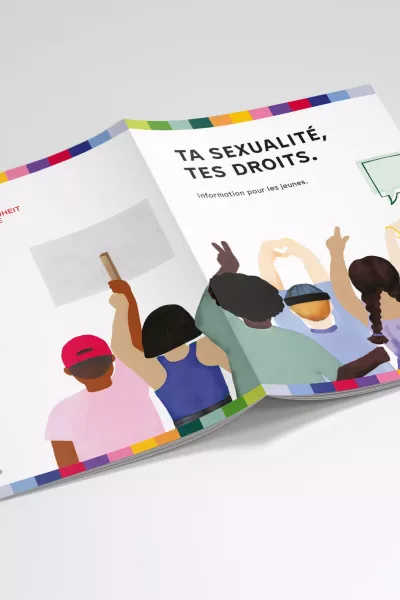 Open magazine with the title page „Deine Sexualität – Deine Rechte.“ (Your sexuality – your rights) and an illustration of young people holding up signs and making hand gestures