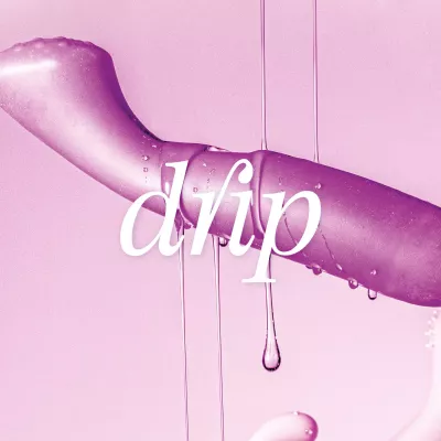 Ein lila Sexspielzeug schwebt vor einem rosafarbenen Hintergrund. Die weiße Aufschrift „drip“ ist darüber gelegt. Klare dickflüssige Flüssigkeit tropft herunter
