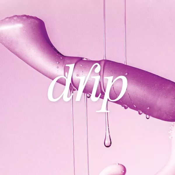 A purple sex toy floats in front of a pink background. The white inscription „drip“ is superimposed on it. Clear, viscous liquid drips down
