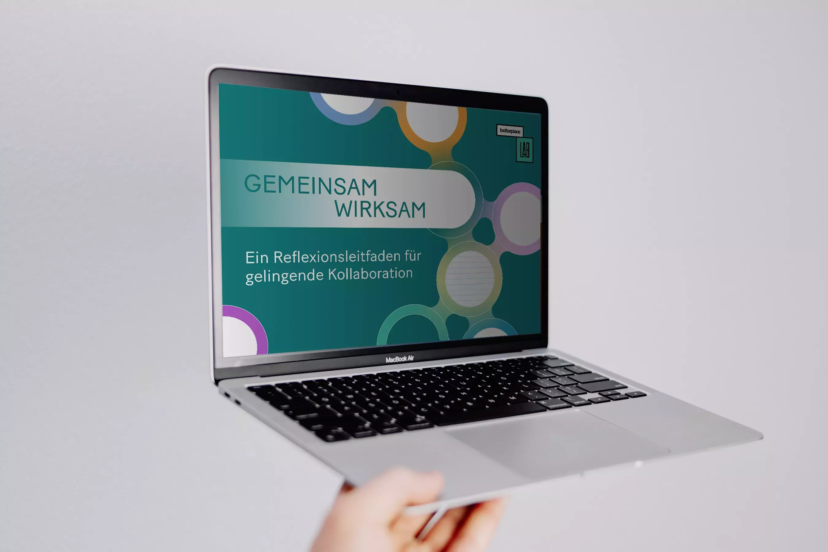 Eine Person hält einen Laptop mit dem Cover \