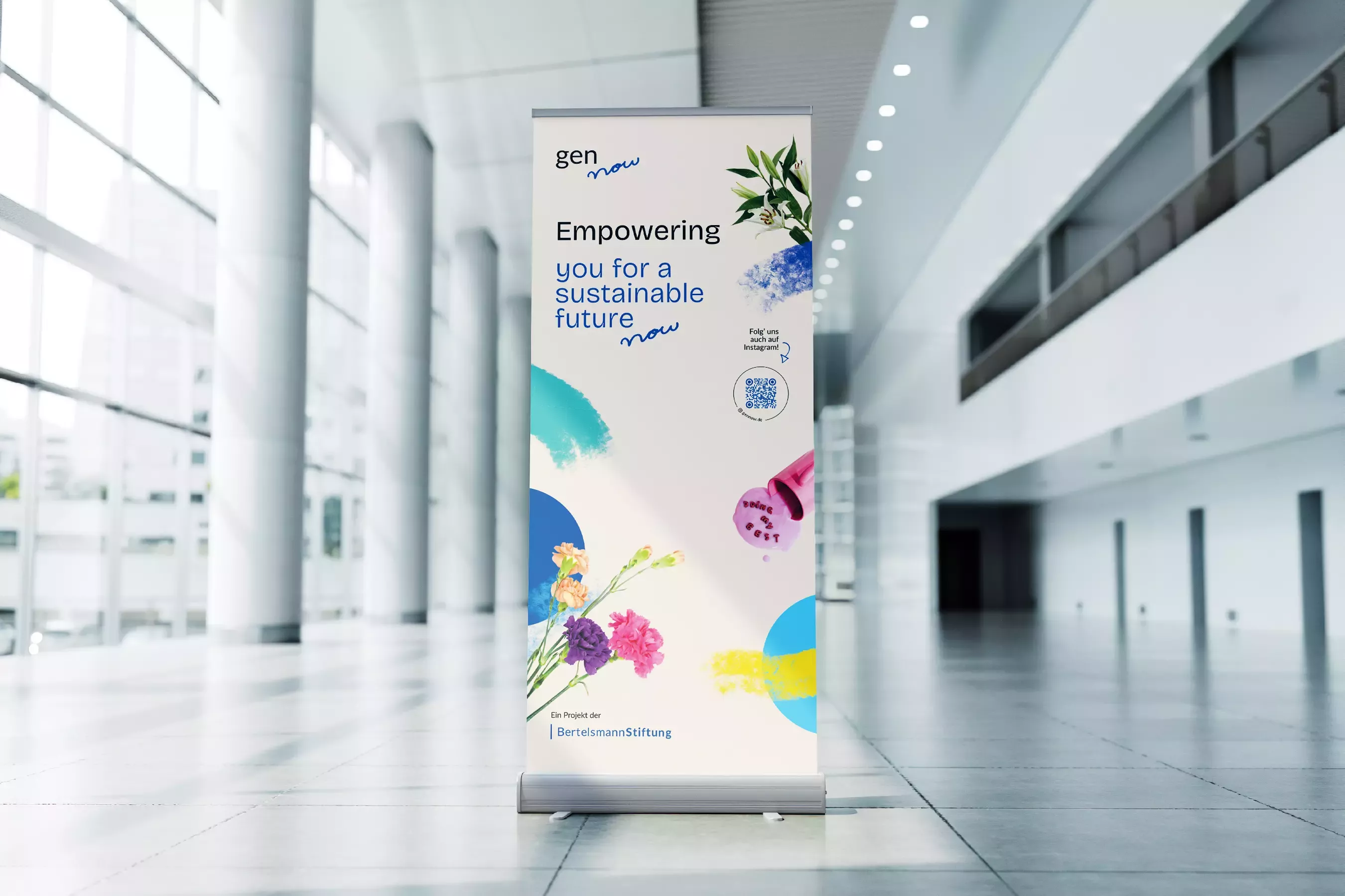 Roll-up Banner von gen now in einer hellen Halle mit dem Text \