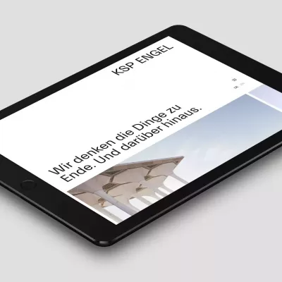 Tablet liegt auf einer grauen Fläche und zeigt die Webseite des Architekturbüros von KSP Engel Architekten mit der Überschrift „Wir denken die Dinge zu Ende Und darüber hinaus“