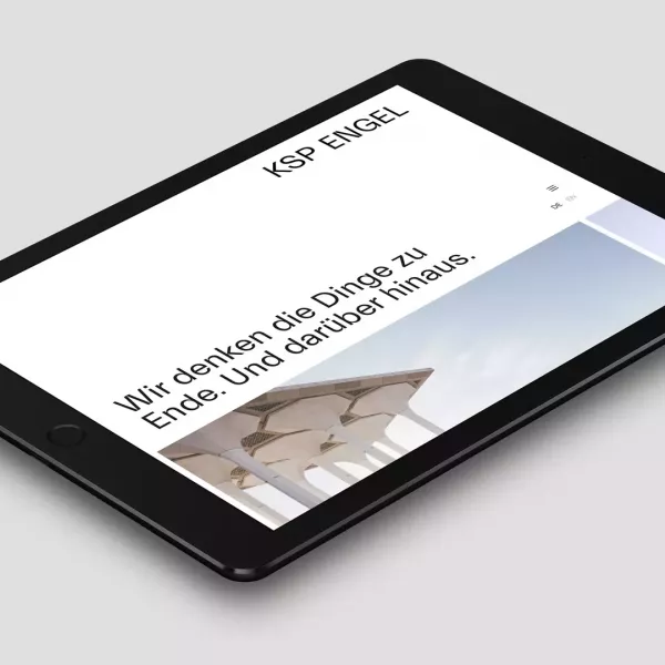 Tablet lies on a gray surface and displays the website of the architectural firm KSP Engel Architekten with the headline „Wir denken die Dinge zu Ende Und darüber hinaus“ (We think things through to the end and beyond.)
