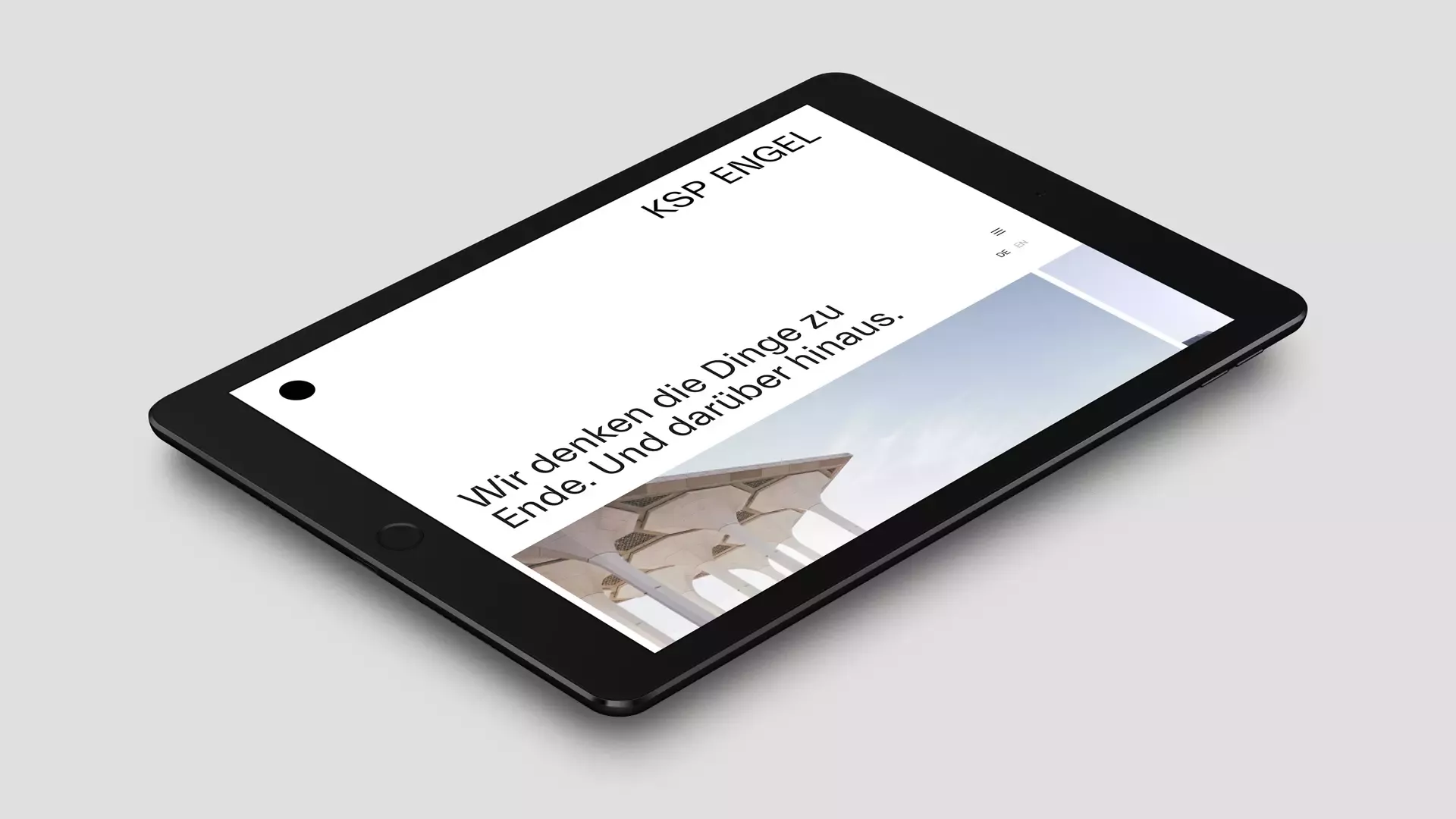 Tablet lies on a gray surface and displays the website of the architectural firm KSP Engel Architekten with the headline „Wir denken die Dinge zu Ende Und darüber hinaus“ (We think things through to the end and beyond.)