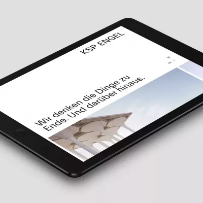 Tablet liegt auf einer grauen Fläche und zeigt die Webseite des Architekturbüros von KSP Engel Architekten mit der Überschrift „Wir denken die Dinge zu Ende Und darüber hinaus“