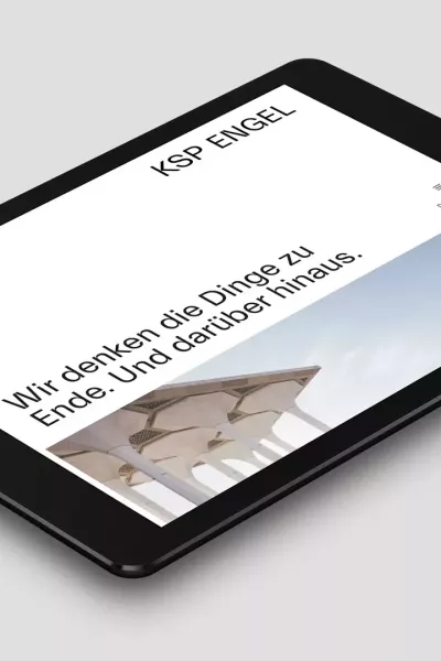 Tablet liegt auf einer grauen Fläche und zeigt die Webseite des Architekturbüros von KSP Engel Architekten mit der Überschrift „Wir denken die Dinge zu Ende Und darüber hinaus“