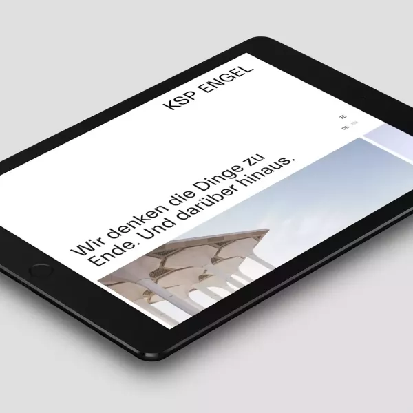 Tablet liegt auf einer grauen Fläche und zeigt die Webseite des Architekturbüros von KSP Engel Architekten mit der Überschrift „Wir denken die Dinge zu Ende Und darüber hinaus“